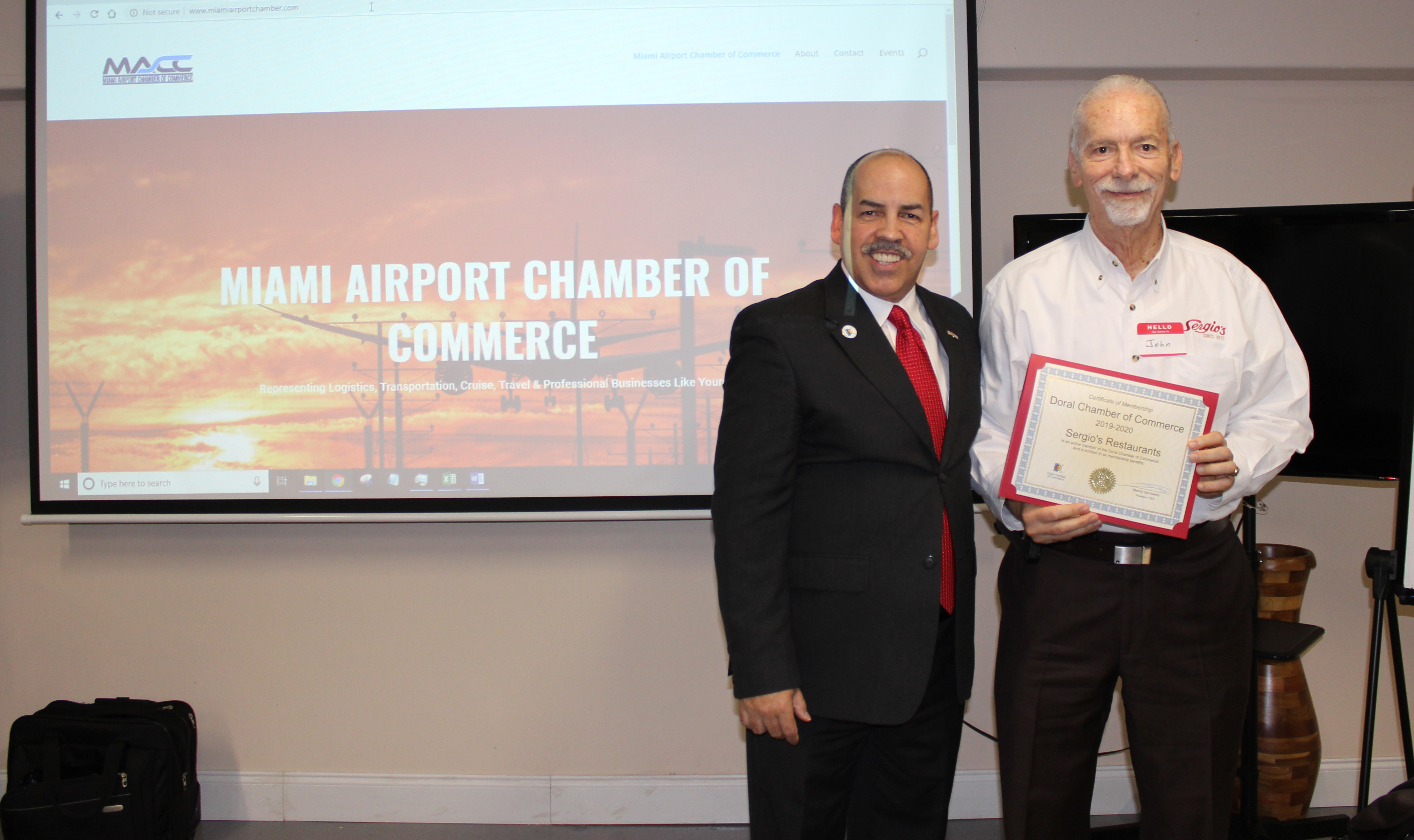 Doral Chamber of Commerce introduces Circle of Success event, photo with Miami Airport Chamber of Commerce background and with Sergio's owner.