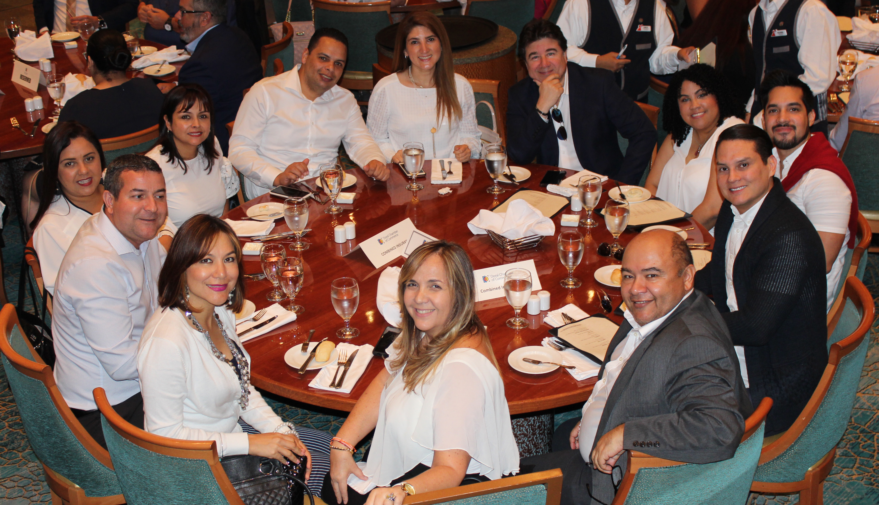 Doral Chamber of Commerce Carnival Cruise Luncheon 2019, Networking Event in Miami, Florida. Entire table taking a group photo.
