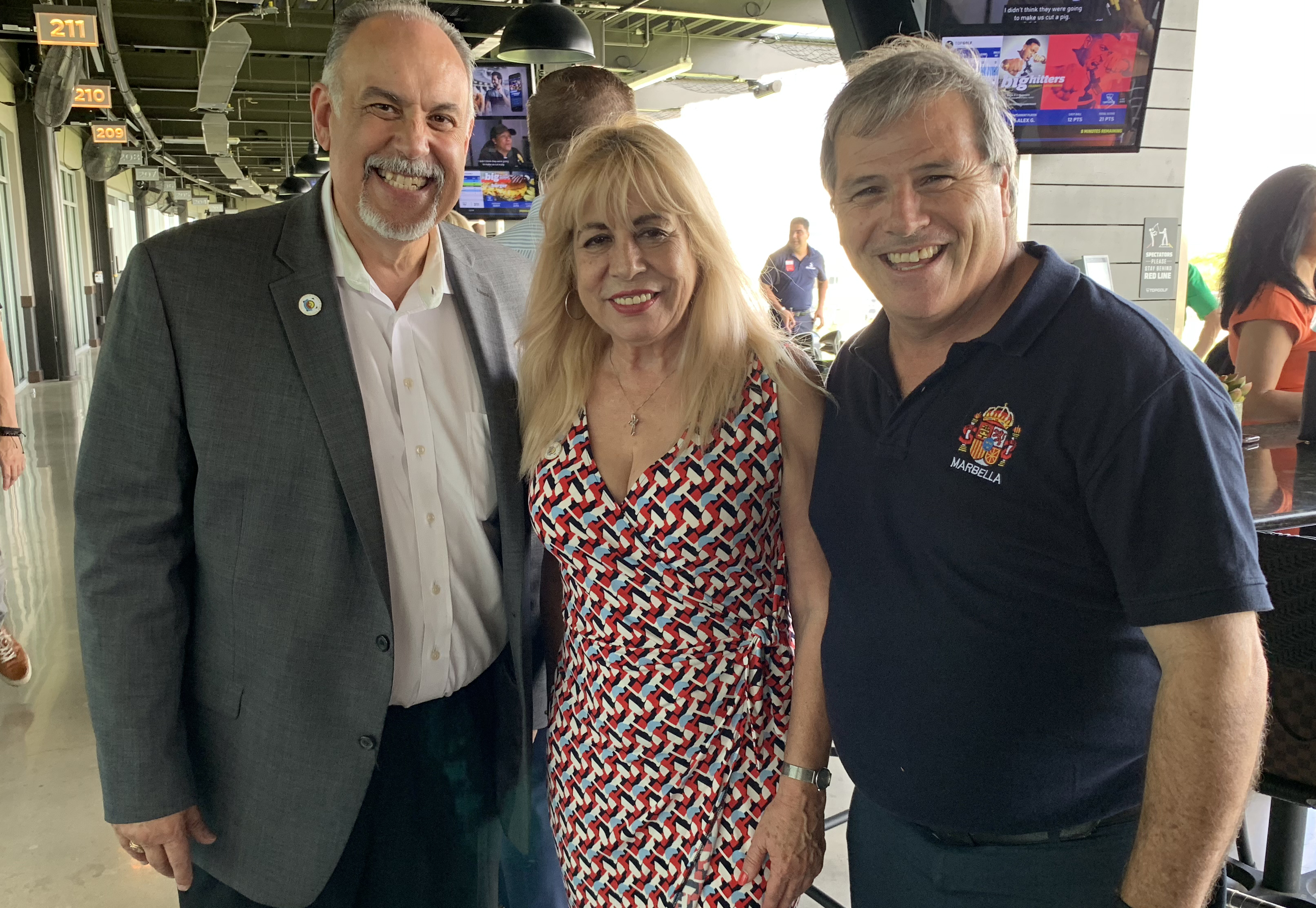 Doral Chamber of Commerce introduces Carmen Lopez taking a photo with two members at Topgolf Doral Networking Luncheon Event.