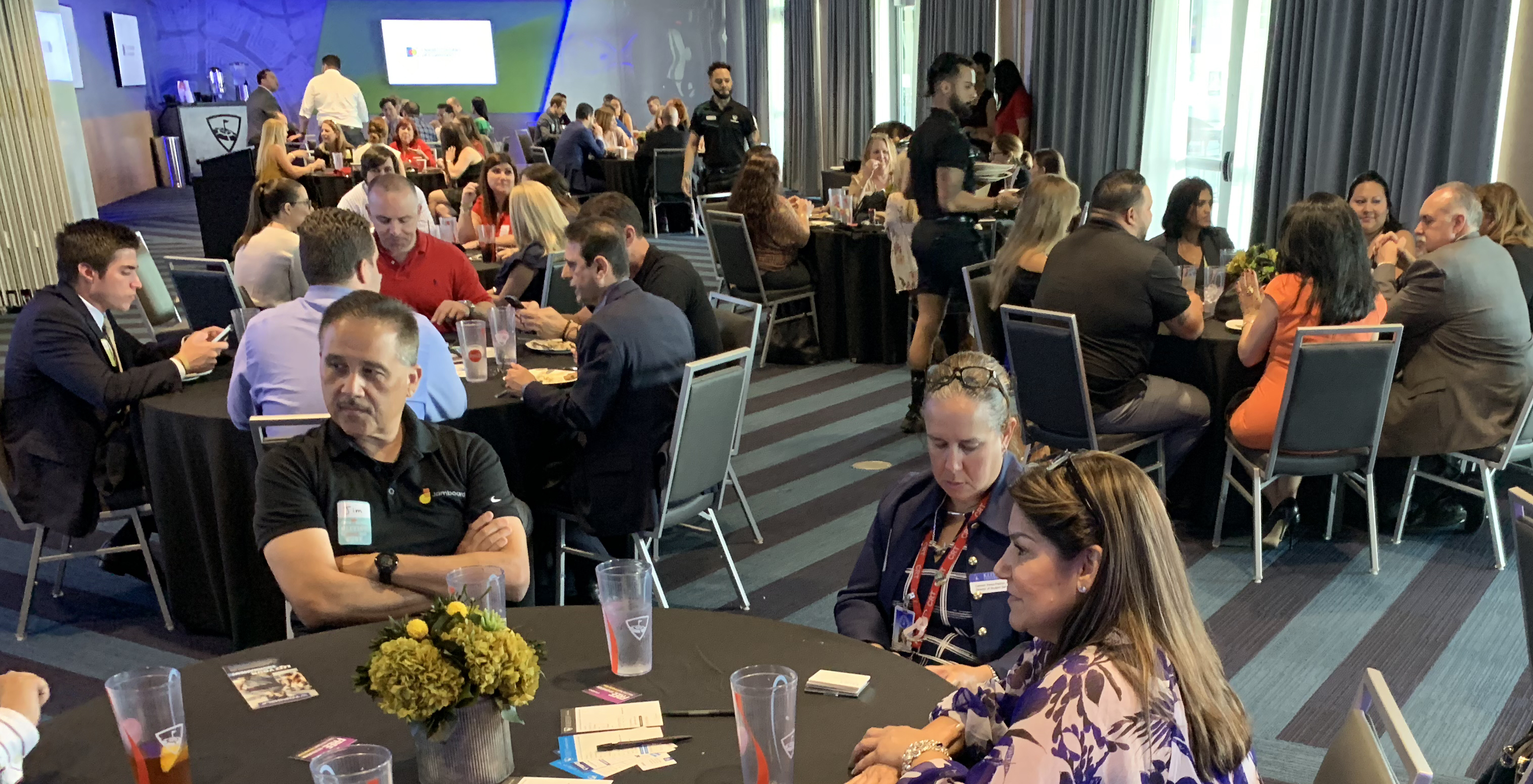 Doral Chamber of Commerce introduces members networking and being served drinks at Topgolf Doral.